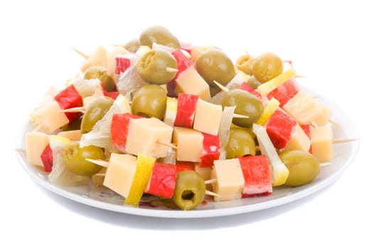 close-up canape on plate with olive, lemon, crab meat and cheese, isolated on white