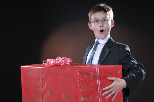 boy in a dark suit gets on the hip bright boxes with gifts