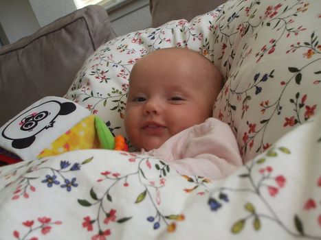 Baby caucasian girl sleeping in parent's bed.