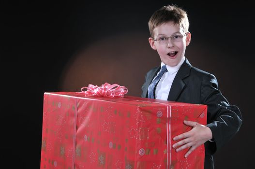 boy in a dark suit gets on the hip bright big boxe with gifts