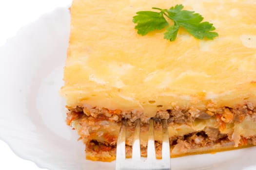 close-up lasagne on plate with fork, isolated on white