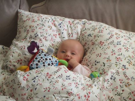 Baby caucasian girl sleeping in parent's bed.