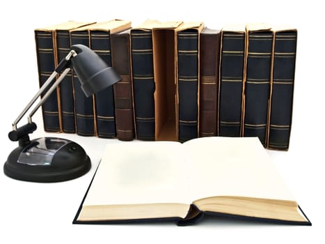 open book and lamp against old book row at white  