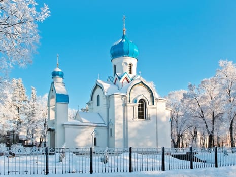 church in winter scenery with white snow and blue sky