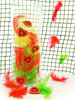 decorative hearts in glass vase against decorated background