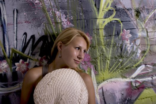girl with graffiti backgroung holding a fan