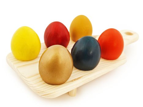 multicolored easter eggs in wooden stand against wjite background