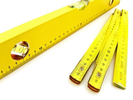 yellow wooden meter and level over the white background  