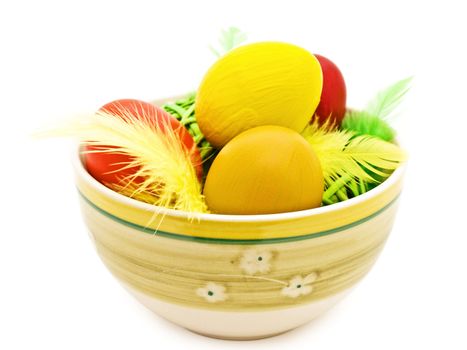 different easter eggs and feathers in the bowl 