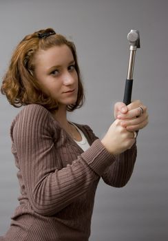 portrait of a beautiful redhaired girl holding a hammer. Be careful!