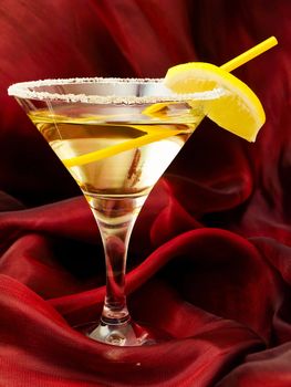 cocktail with lemon at red silk drapery