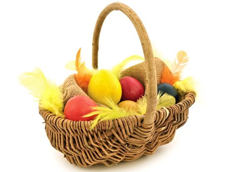 multicolored easter eggs and feathers in the basket
