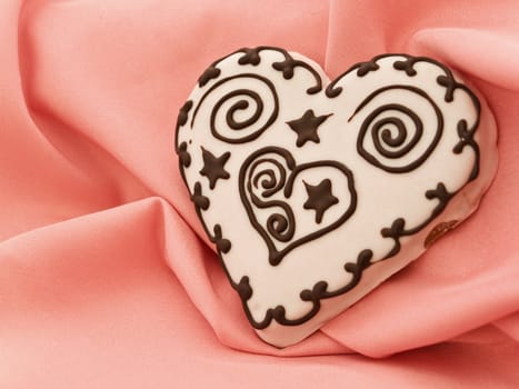 spice cake in heart shape at pink textile drapery