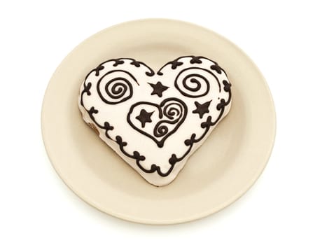 Photo of spice cake in heart shape in plate against white background