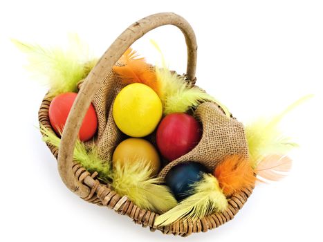 multicolored easter eggs and feathers in the basket
