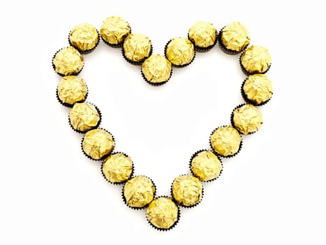heart shape from sweets in golden candy wrapper 
