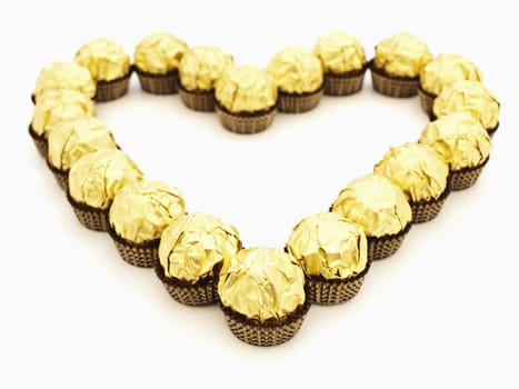 heart shape from sweets in golden candy wrapper 