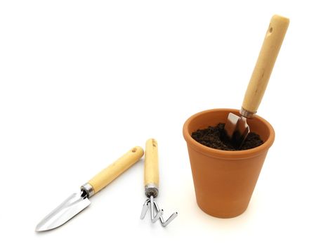 Gardening trowel in pot with black soil against white background. Copyspace for your text