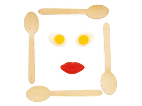 wooden spoons with amazing colorful tasty jelly candies in woman face shape