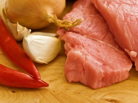 pieces of meat with spices on hardboard
