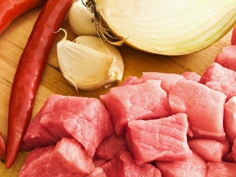 pieces of meat with pepper,garlic and onion on hardboard
