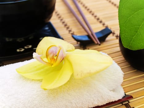 yellow orchid over white towel in oriental caf�