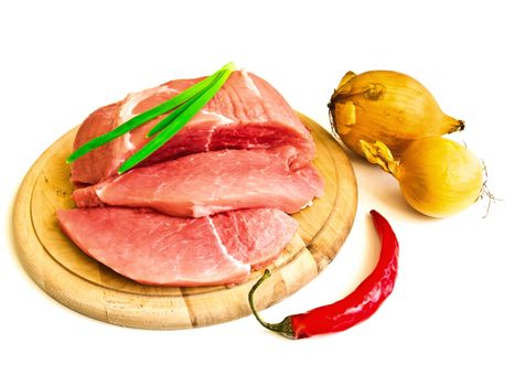 piecies of meat on the hardboard and some vegetables near it
