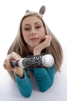 laying woman holding roller comb on an isolated white background