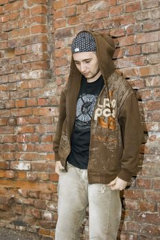 Rapper boy posing at a brick wall, urban scene