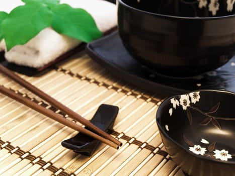 oriental style table serving with bowl and green leaves 