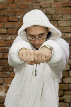 Rapper boy posing at a brick wall, urban scene