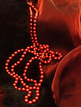  fashion red necklace in chaplet shape over burgundy textile and fur  background