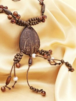  fashion wooden handmade necklace  over golden textile background