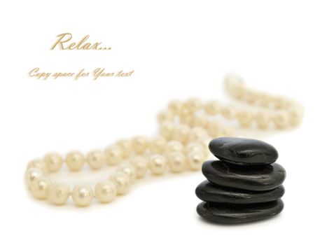 Relax theme with pearl beads and Zen stones over white background