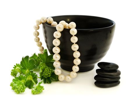 Relax theme with pearl beads, Zen stones and green herb over white background