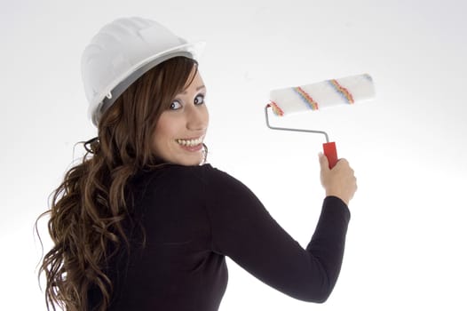 woman with architect helmet and paint brush against white background