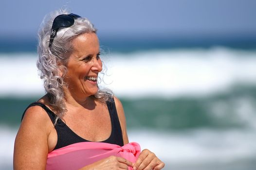 an elder happy woman at the beach