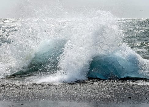 splashing waves on bluegreen segements of glacier ice