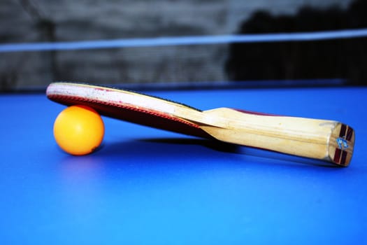 the tennis bat and a ball on a tennis table.