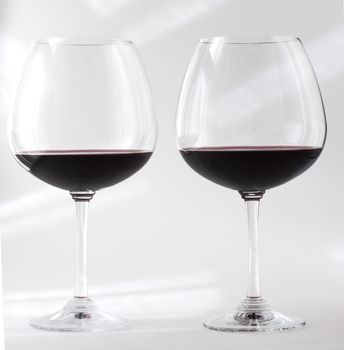 Two glasses of red wine over white background
