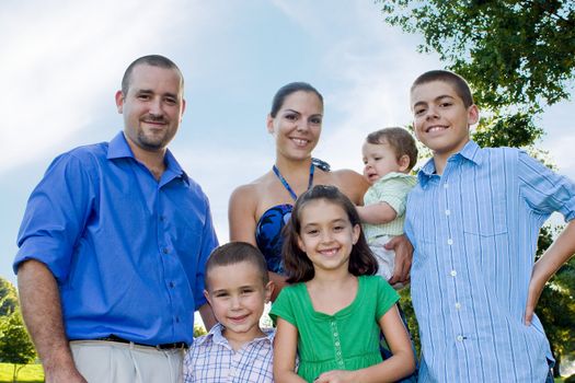 An attractive young family together at the park together on a nice spring or summer day.