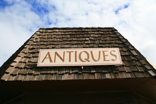 Close up of an antiques sign on top of a store.
