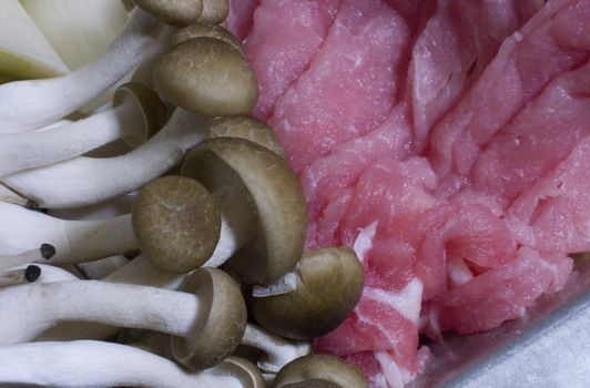 Ingredients for Japanese Shabu-Shabu. mushrooms and pork ready for cooking, white, brown and red.