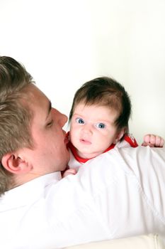 A young father carries his baby lovingly in her arms