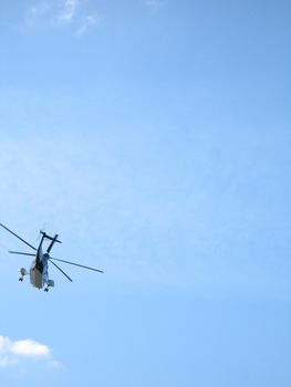a helicopter in the blue cloudy sky