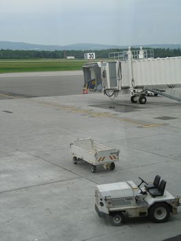 empty airplane gate with small trucks