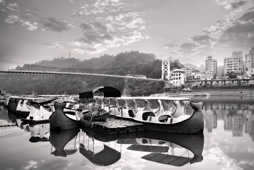 Landscape of river and boats near bridge and apartment.