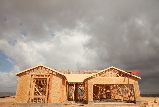 Abstract of New Home Construction Site Framing and Dramatic Clouds Overhead.