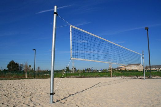 Beach volleyball net over bright blue sky.
