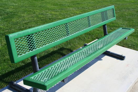 Close up of a green bench in a park.
